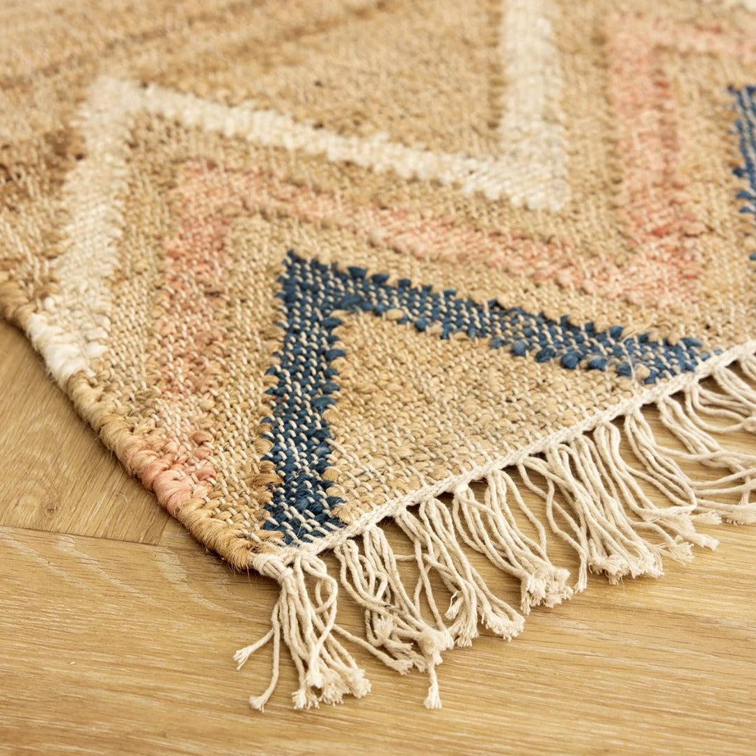 Tæppet er bl.a. lavet i jute, som er et fantastisk naturfiberprodukt og som med det samme giver et rum en dejlig varm atmosfære. Farven er beige/brun med mønster i farverne blå, hvid og lyserød.