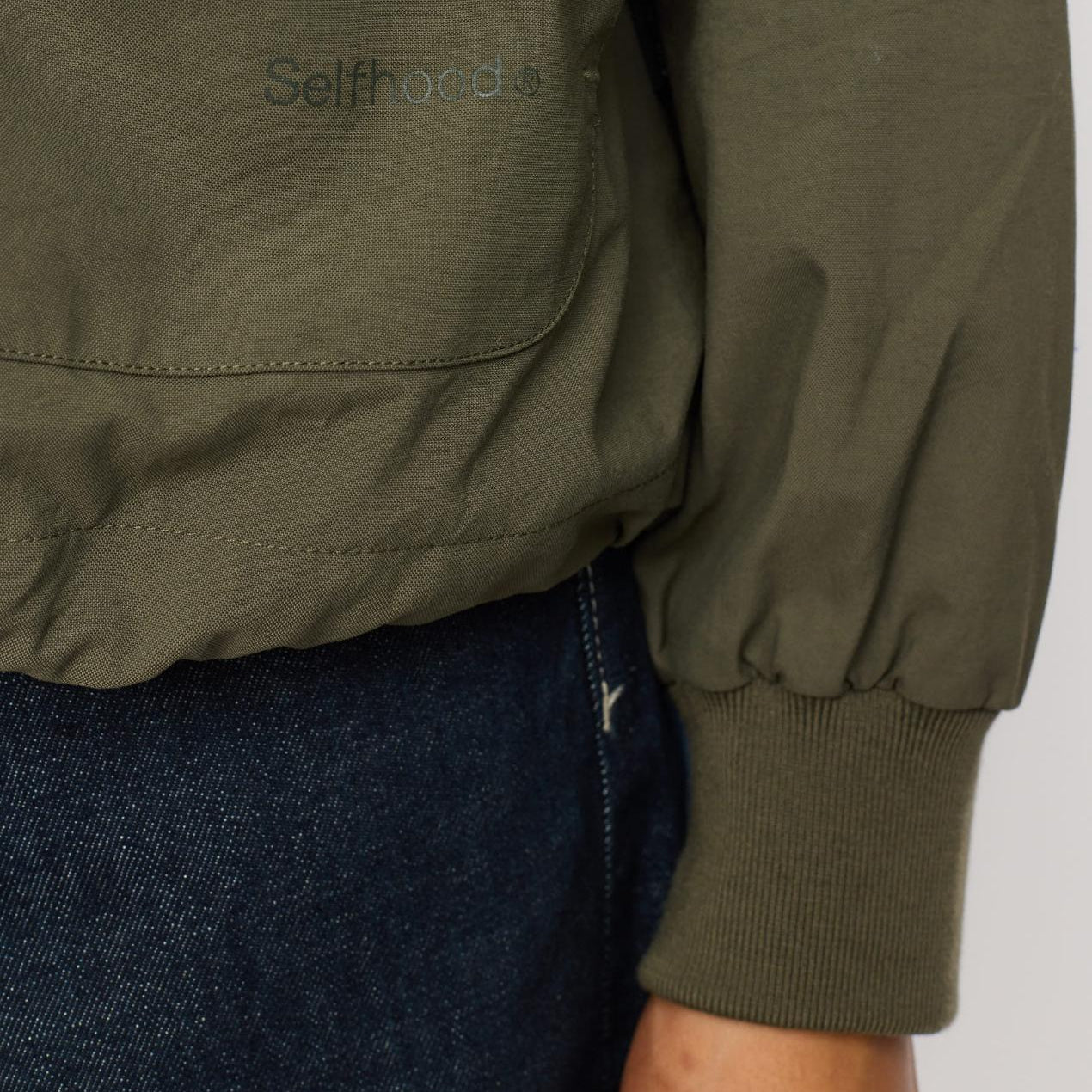 Let jakke i oxford-kvalitet med justerbar snøre i bunden