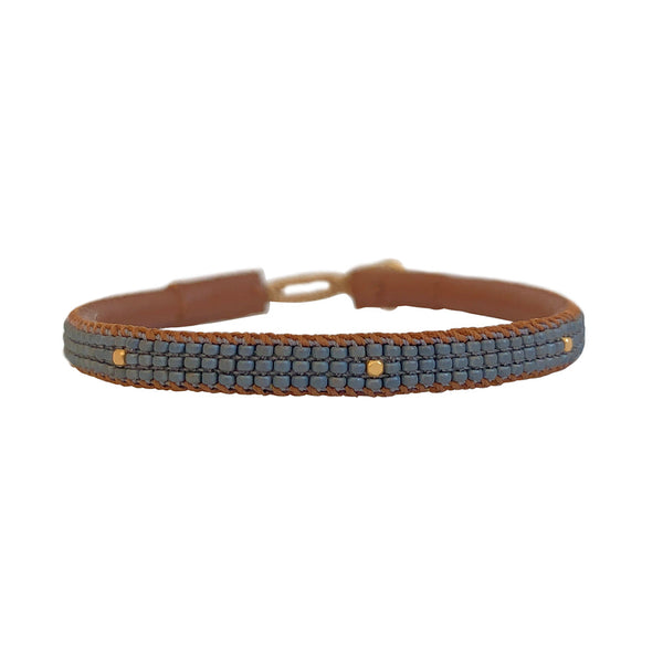 Otto armbåndet fra IBU Jewels er et fint perlearmbånd med en farve som base, hvor der er små guldperler på tværs af armbåndet. Armbåndet er lavet af eksklusive Miyuki-perler, som er håndsyet på blødt læder. Denne model er med grå perler som base.
