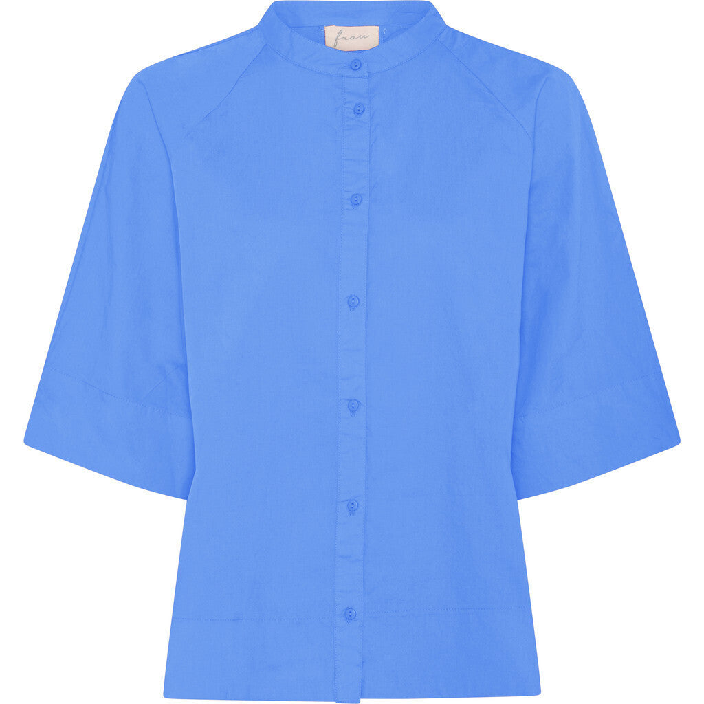 Abu Dhabi skjorten fra FRAU er en kort skjorte med kinakrave, som er gennemknappet og har læg på ryggen. Denne er i farven 'Granada Sky', som er en blå farve