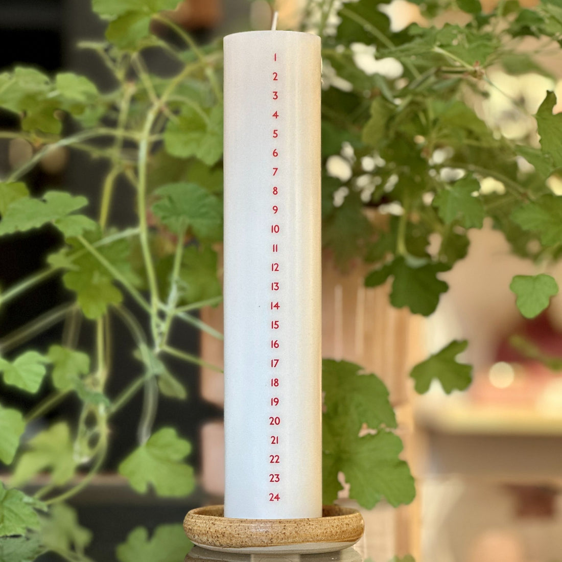 Højt hvidt kalenderlys med røde tal. Kalenderlyset består af 51% sojavoks og 49% stearin, og er derfor det tætteste, man kan komme på et soja-kalenderlys.