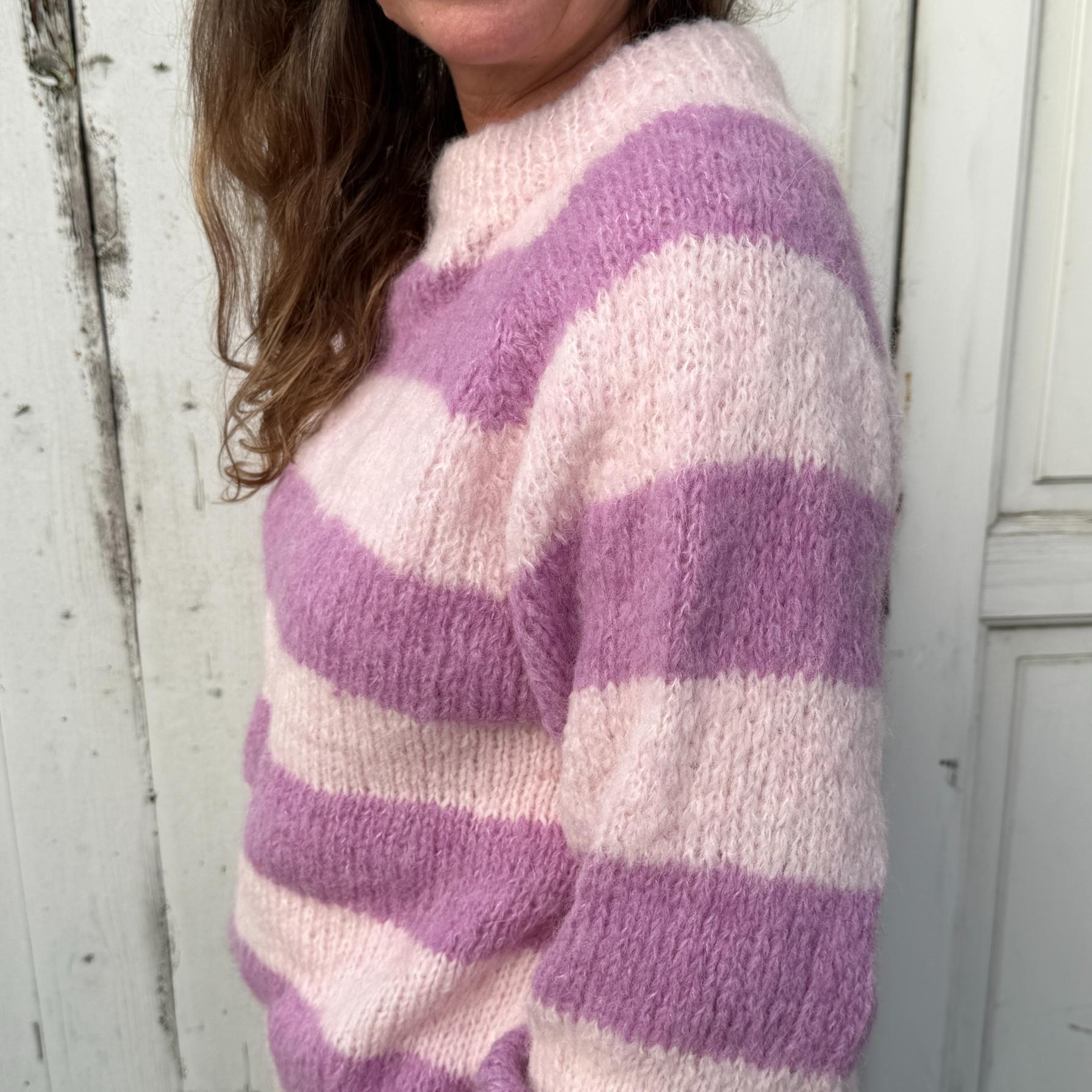 Den håndstrikkede Ida sweater fra Coffee Beanies er en varm og luksuriøs trøje i italiensk alpakauldsblanding - den er lilla med striber og her er et close up billede