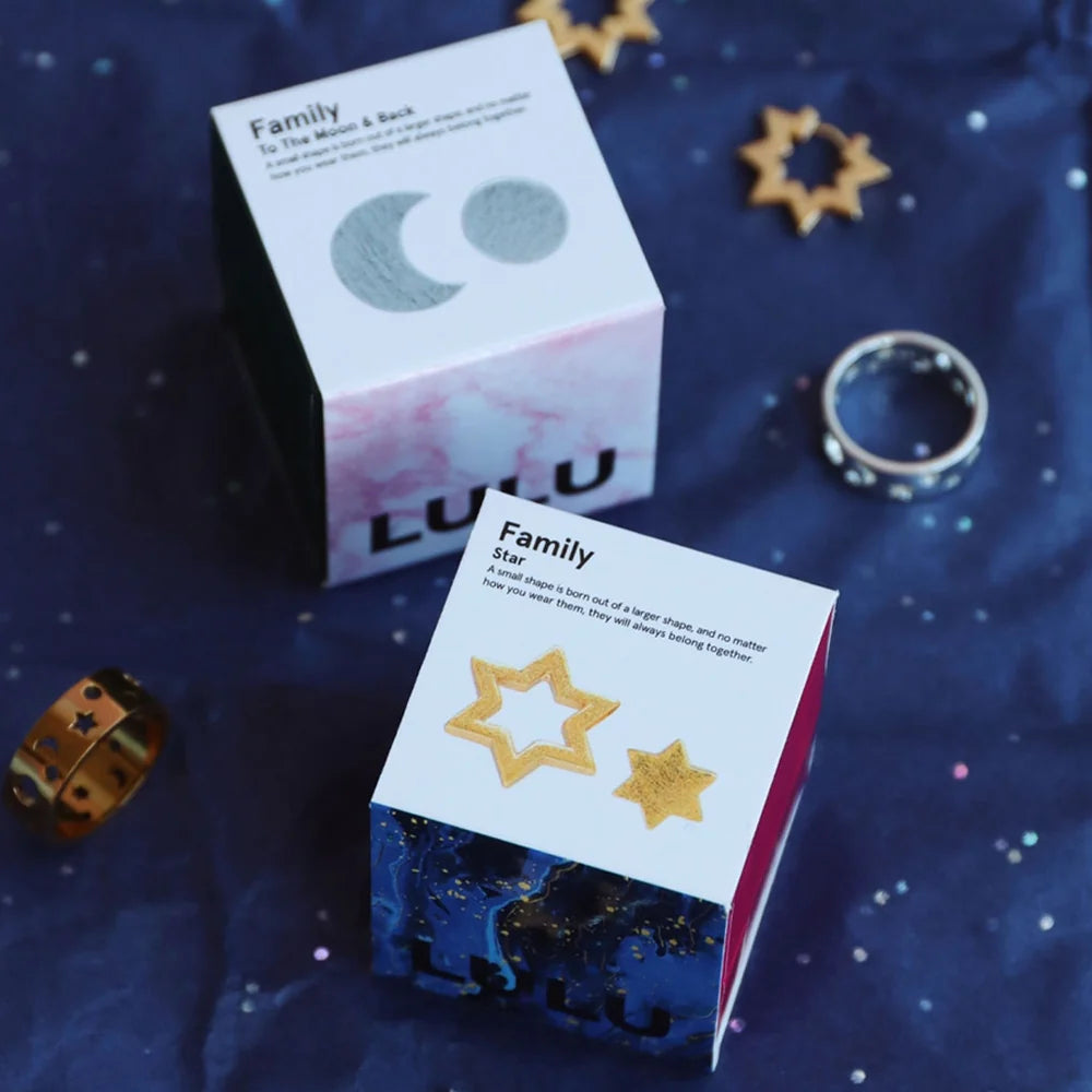 Family star øreringene fra LULU Cph er et par øreringe, hvor den ene hører unægteligt til den anden. Dette sæt består af en fyldt stjerne og et omrids af en stjerne i guld