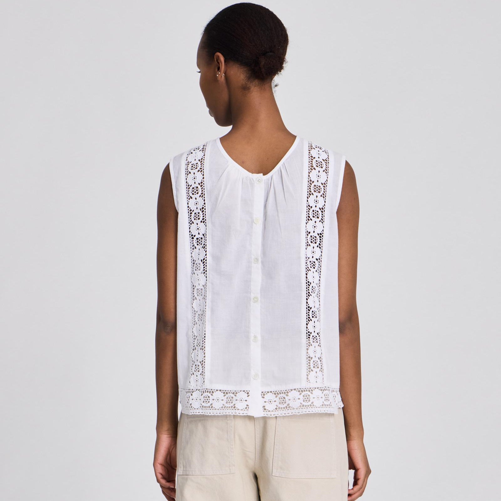 Rosita bomuldstop med læg foran og knaplukning i ryggen.