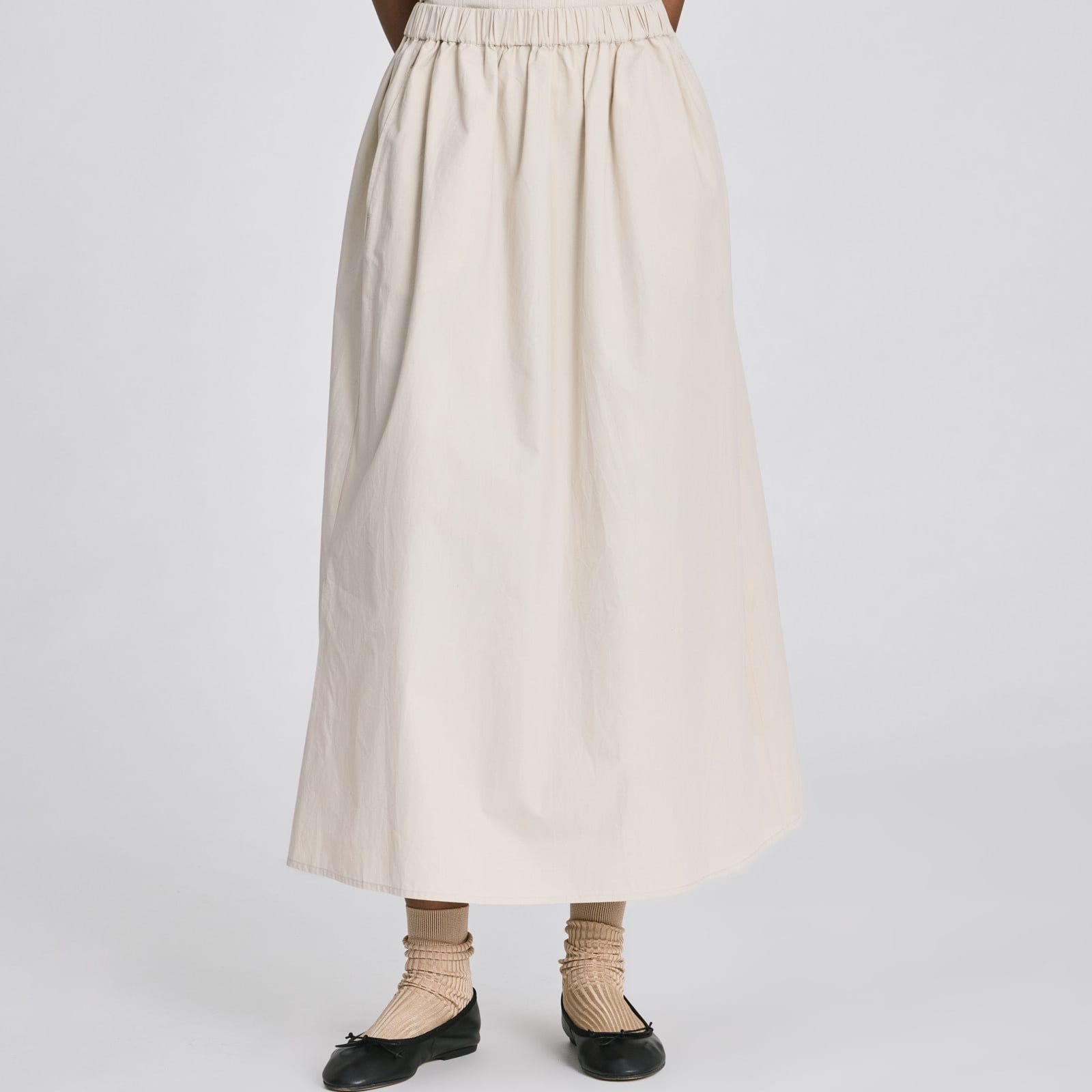 Alice Skirt i cremehvid økologisk bomuldspoplin med elastisk talje og lang silhuet.