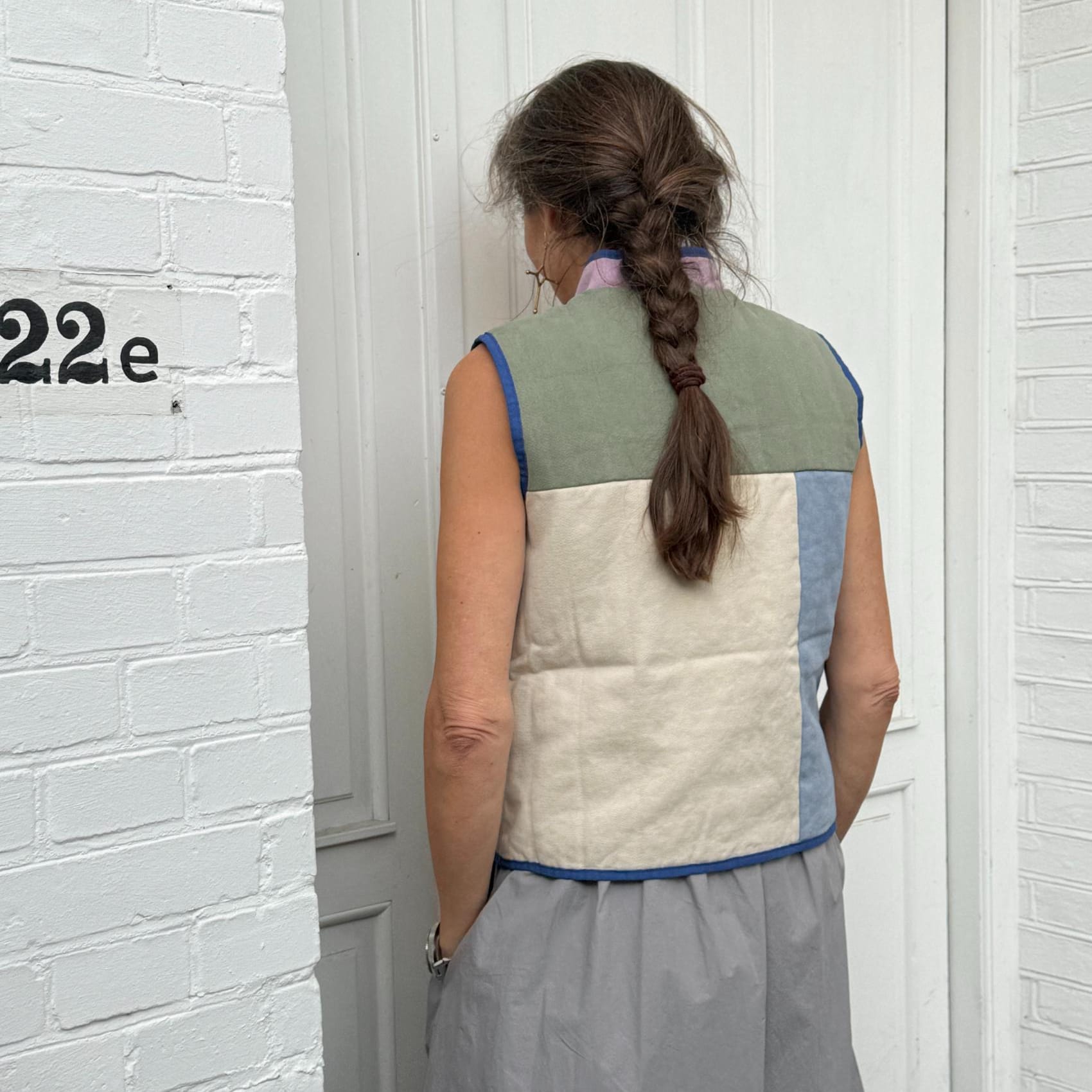 Moderne vest med blå piping og dekorative lommer
