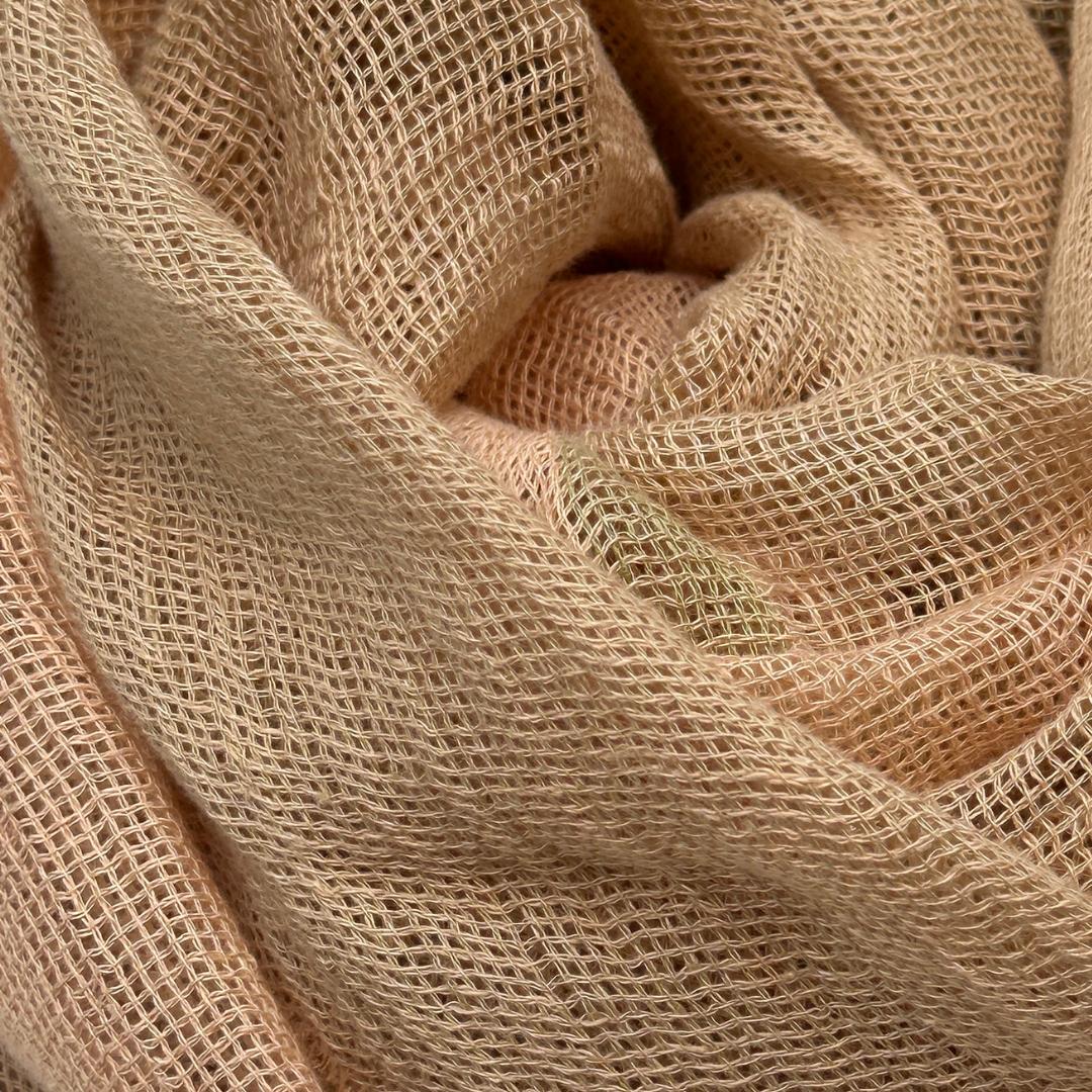 Et beige tørklæde. Tørklædet er lavet i hør