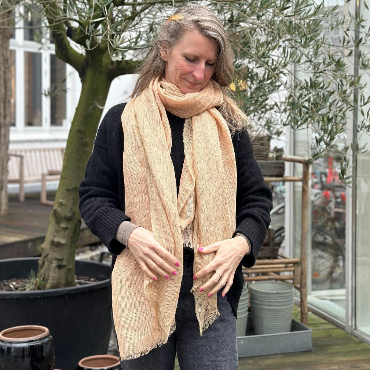 Et beige tørklæde. Tørklædet er lavet i hør