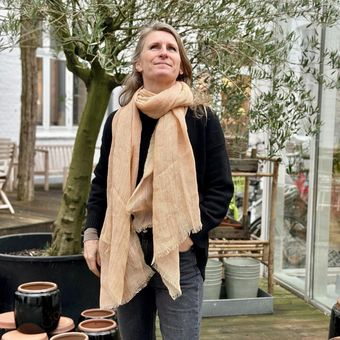 Et beige tørklæde. Tørklædet er lavet i hør