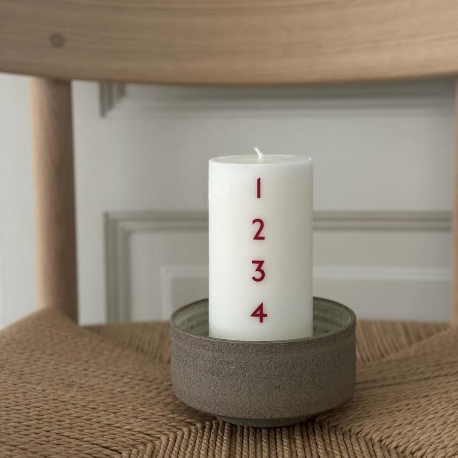 Bredt adventslys med røde tal. Adventsyset består af 51% sojavoks og 49% stearin, og er derfor det tætteste, man kan komme på et soja-kalenderlys.