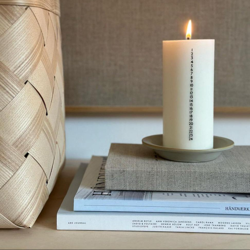Hvidt kalenderlys med sorte tal. Kalenderlyset består af 51% sojavoks og 49% stearin, og er derfor det tætteste, man kan komme på et soja-kalenderlys.