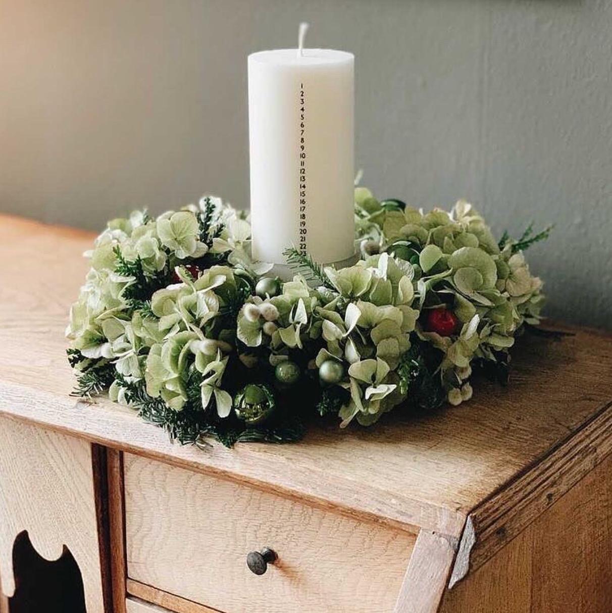 Hvidt kalenderlys med sorte tal. Kalenderlyset består af 51% sojavoks og 49% stearin, og er derfor det tætteste, man kan komme på et soja-kalenderlys.