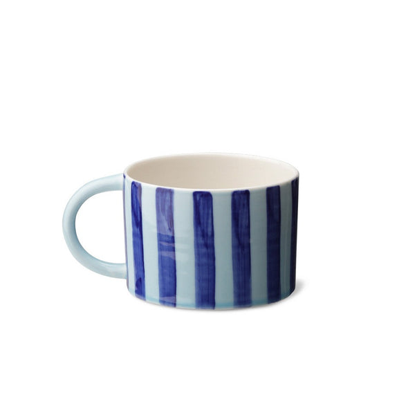 CANDY CUP WIDE, i størrelse large, er en lav, men bred kop med hank. Den er skabt med opmærksomhed på detaljen og er håndlavet af keramik af god kvalitet.  Denne er blå med mørkeblå lodrette striber