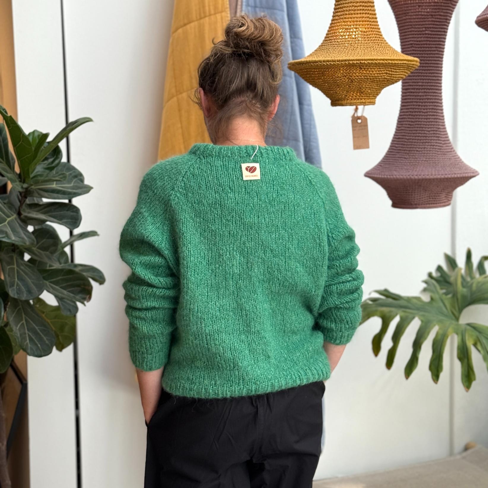Grøn Striktrøjen fra Coffee Beanies. En klassisk striktrøje med rund hals og lange ærmer. Trøjen er lavet i 100% blød alpakauld og er onesize - her ses den bagfra