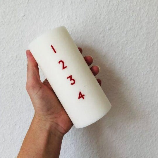 Bredt adventslys med røde tal. Adventsyset består af 51% sojavoks og 49% stearin, og er derfor det tætteste, man kan komme på et soja-kalenderlys.