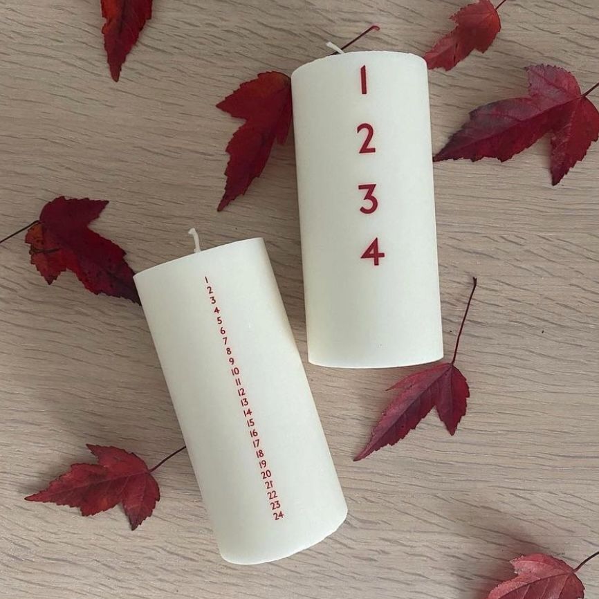 Bredt adventslys med røde tal. Adventsyset består af 51% sojavoks og 49% stearin, og er derfor det tætteste, man kan komme på et soja-kalenderlys.
