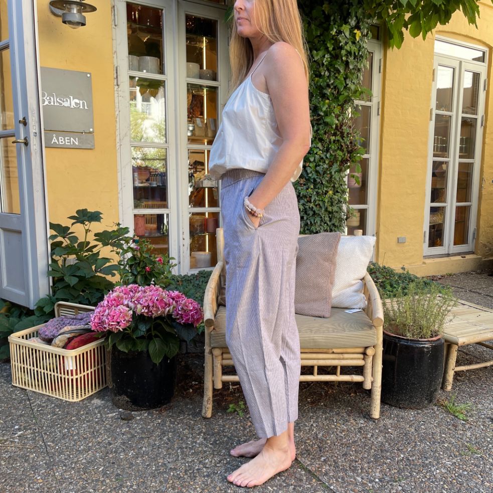 FRAU bukserne model OSLO har bred elastik i taljen og er lavet i økologisk bomuld. Her i varianten coffee quartz stribe