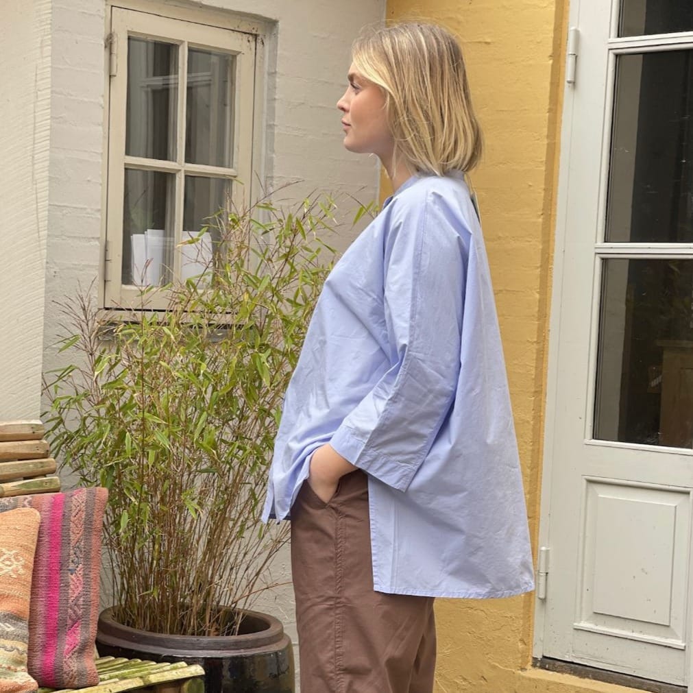 Lyseblå oversized skjorte i enkelt design med 3/4 ærmer og kinakrave. Skjorten er lidt længere bagpå og runder fint foran. Skjorten har stolpelukning, og er lavet i en let økologisk bomuldspoplin, som gør skjorten åndbar og behagelig at have på. Skjorten er one size og passer str 34-44.