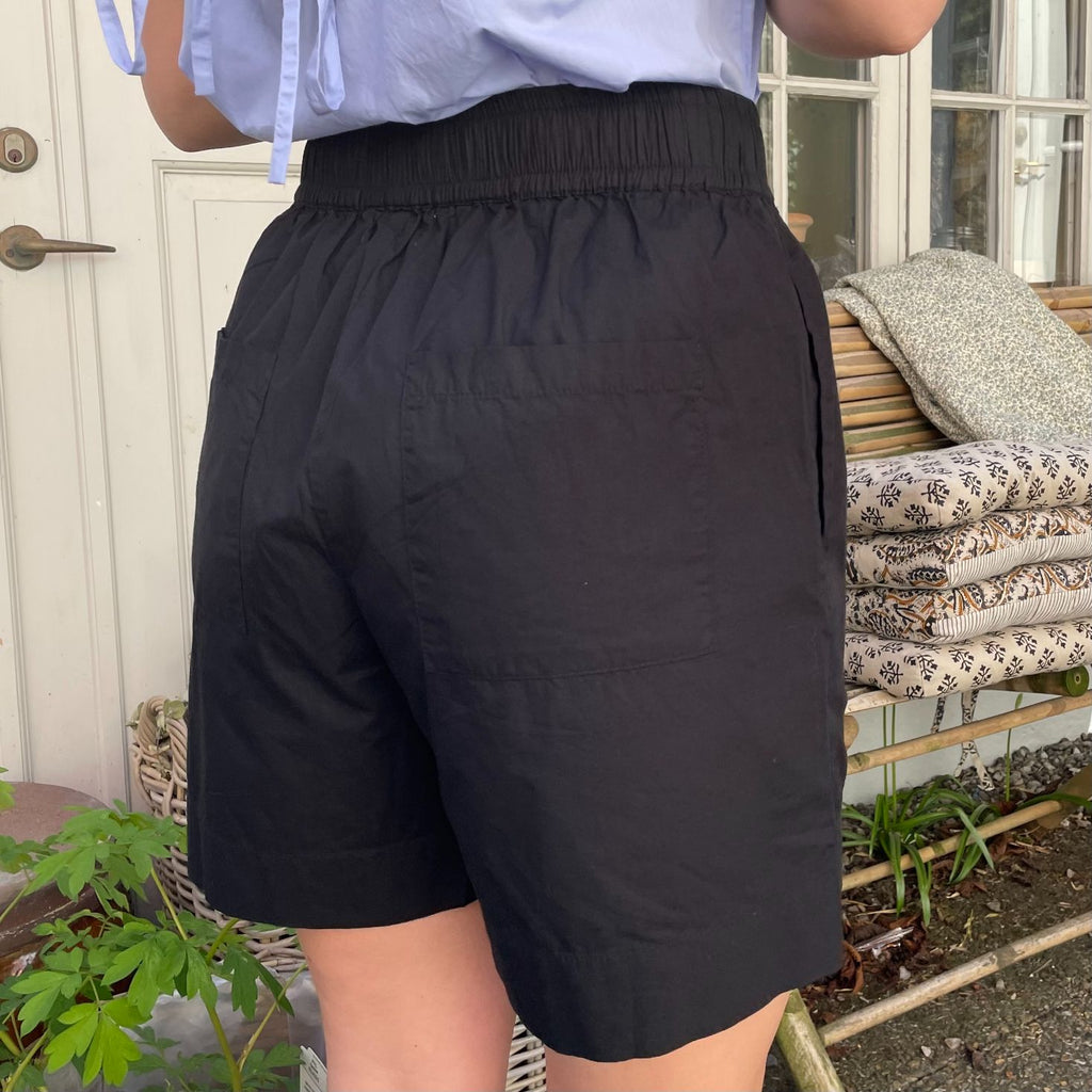 De nye Sydney Shorts i sort er endnu en tidløs klassiker til din garderobe fra danske Frau. Shortsene er lavet i et enkelt design med vide ben, baglommer, bred elastik i taljen og bindebånd.