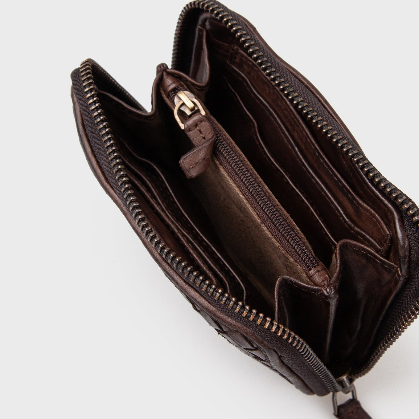 Mørkebrun pung fra montana est i flettet læder med lynlåslukning set oppe fra