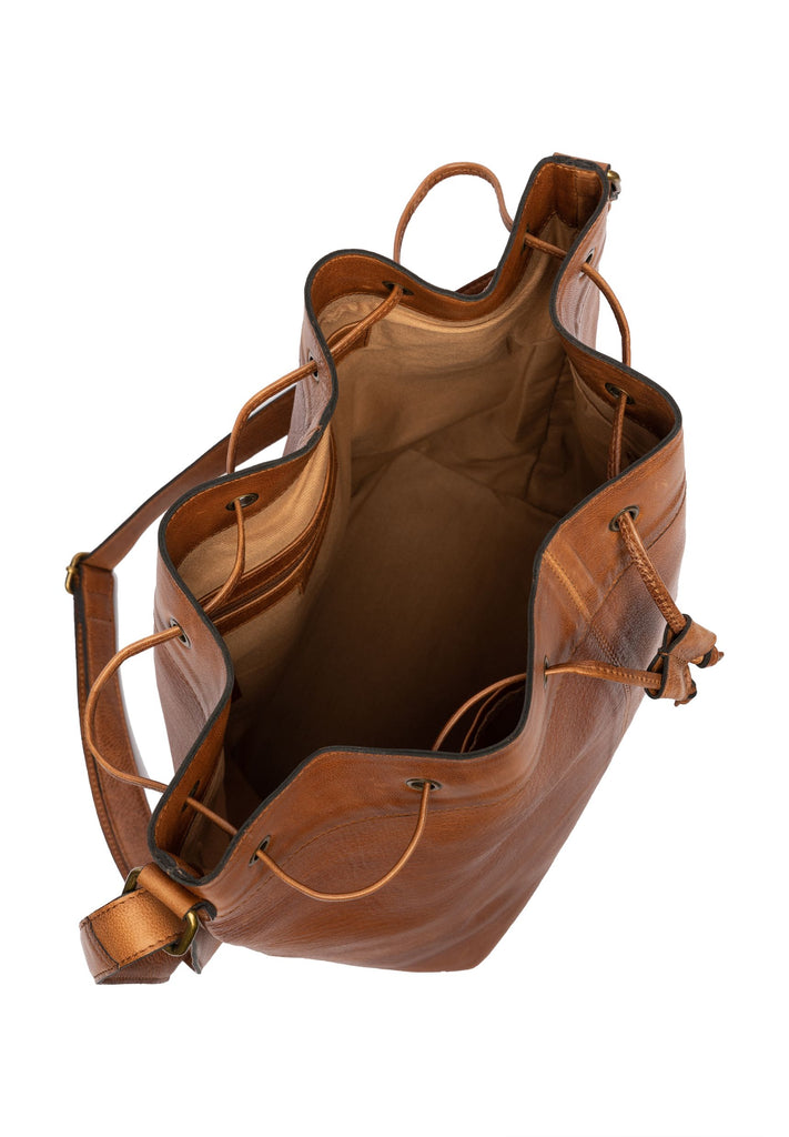 Enia tasken har en flad og rund bund samt snøre i toppen, som gør, at du kan spænde den ind. Der medfølger en crossover-rem, og du kan dermed også bruge den som en skuldertaske.