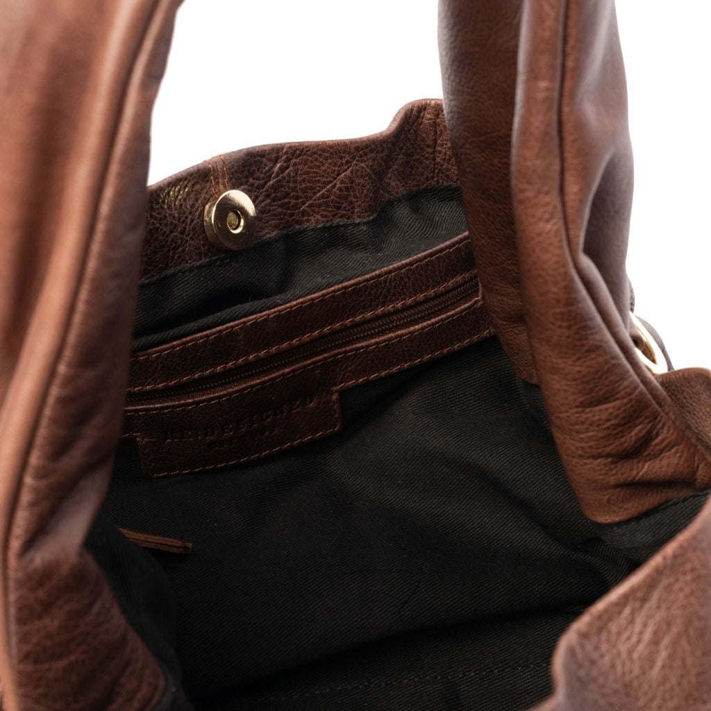 Emery tasken er en stilfuld skulder- og crossbody taske, som både fungerer til finere brug og til hverdag.  Tasken lukkes med en magnetspænde, og indeni er der en lynlåslomme og 2 åbne lommer. Tasken har en bred blød skulderrem og kommer med en crossover-rem, som kan justeres og tages af.