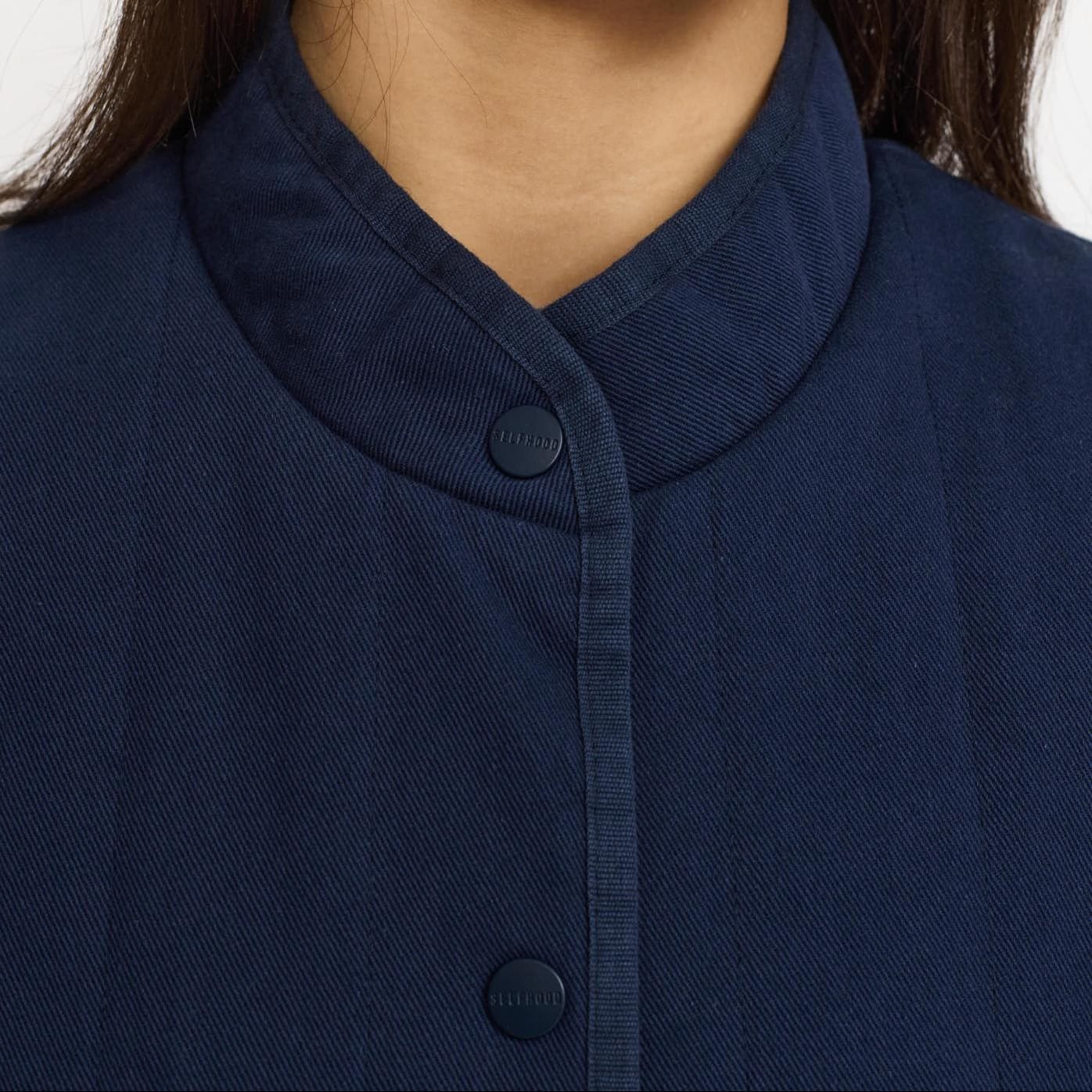 Closeup af krave på blå quilt vest fra Selfhood