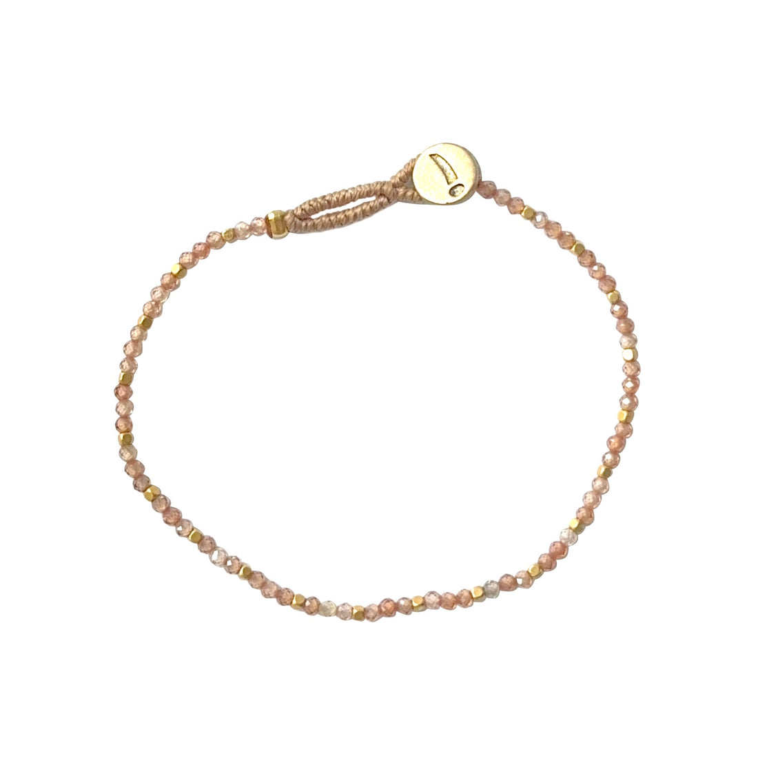 Et fint tynd armbånd fra Ibu Jewels med lyserøde perler, og med få guld perler i mellem dem 