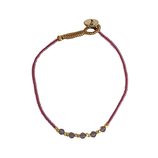 'Lulu 5 Stone' perlearmbåndet fra IBU Jewels er et elegant armbånd bestående af små farvede perler, små guldperler og 5 lidt større halvædelsten på midten. De forskellige størrelser perler giver fint spil i armbåndet og fremhæver perlerne hver for sig. 'Maroon' består af farvede røde perler samt to guldperler omkring hver halvædelsten. Der er i alt 5 halvædelsten på midten af armbåndet.