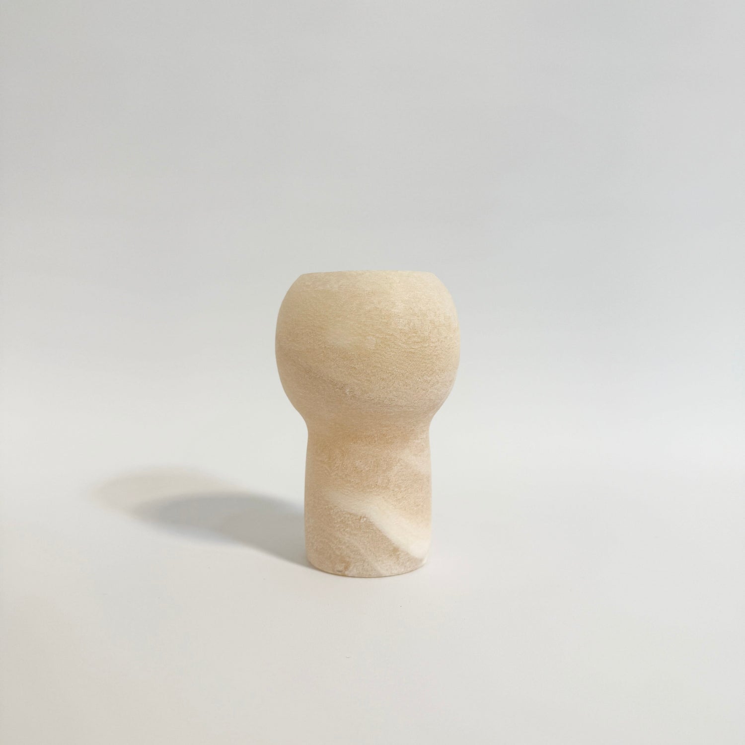 Minimalistisk alabast lysestage med naturlige farvespil og elegant finish.