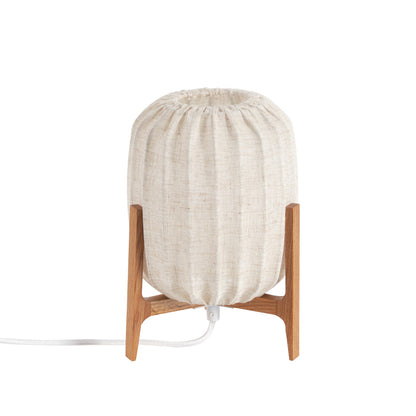 Klassisk bordlampe med egetræsfod og beige hørskærm i tidløst design