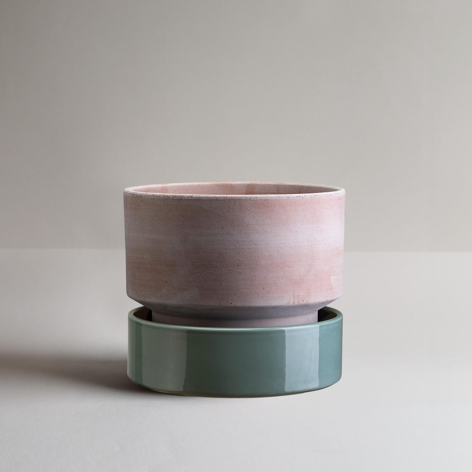 Bergs Potter - The Low Pot i farven Raw Rose sammensat med en blå glaseret underskål. 