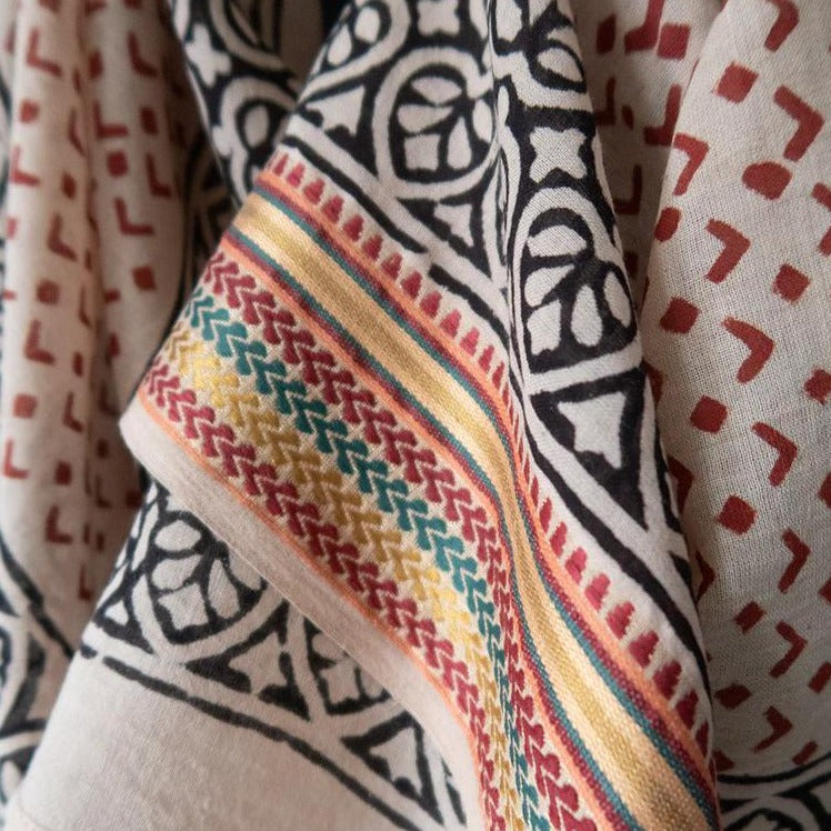 Smukt og let bomuldstørklæde med guldkanter håndlavet i Indien. Den er hvid med rød mønster