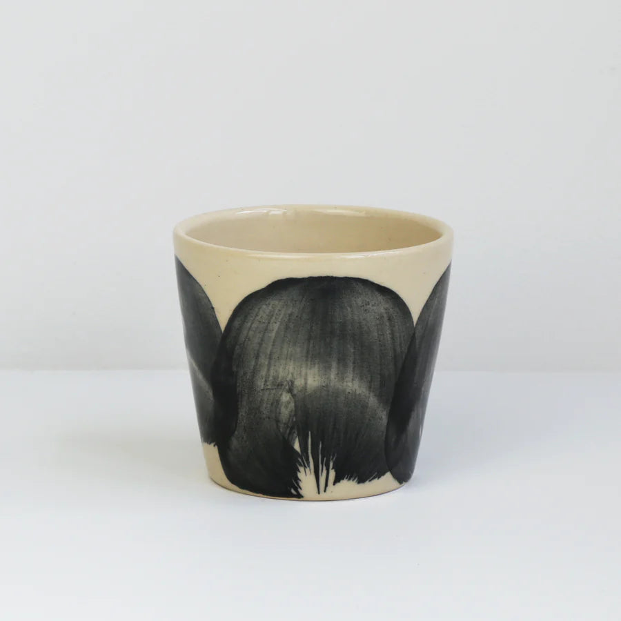 En lille keramik kop fra Bornholm i creme med sort brush effekt