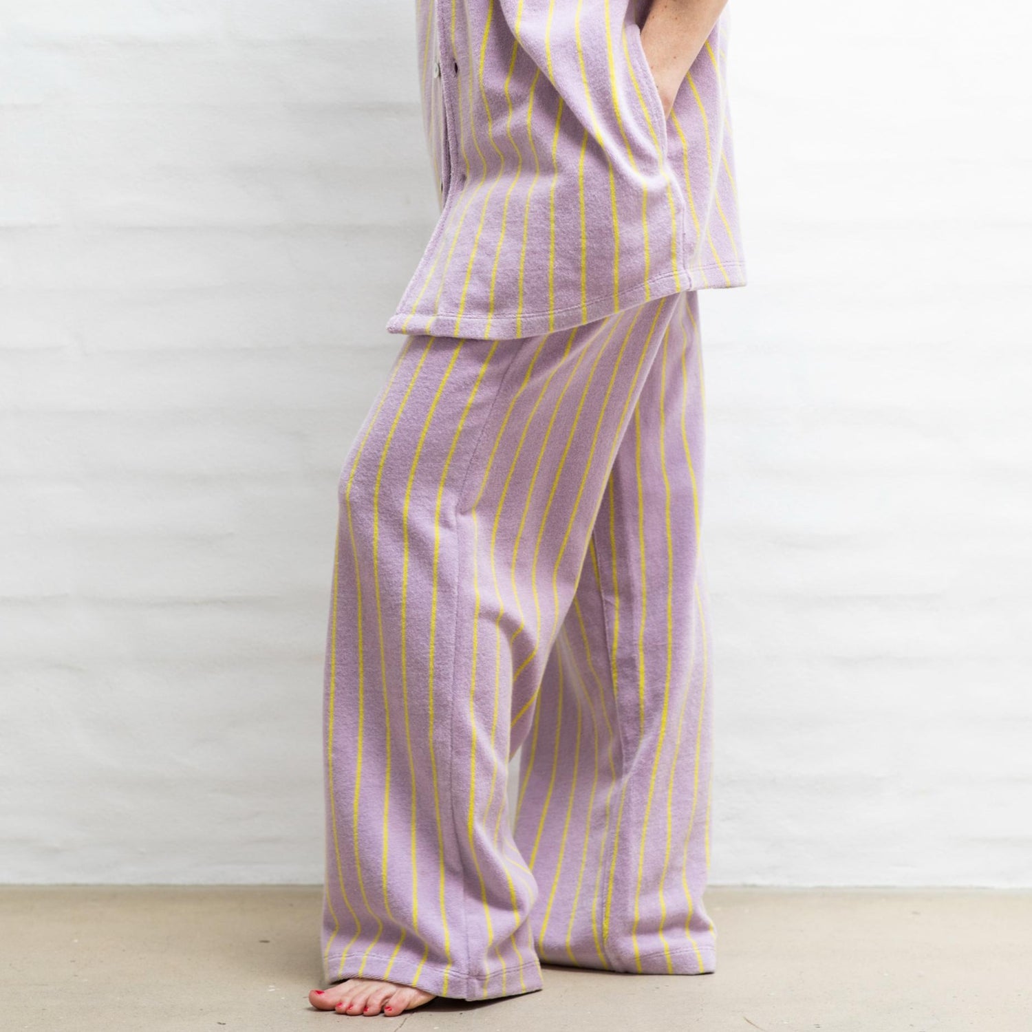 Disse lilla bukser har en tynd gul stribe og er lavet i 100% bomuldsfrotté. De har en cool og afslappet pasform, hvilket giver et behageligt look, der er nemt at style. 