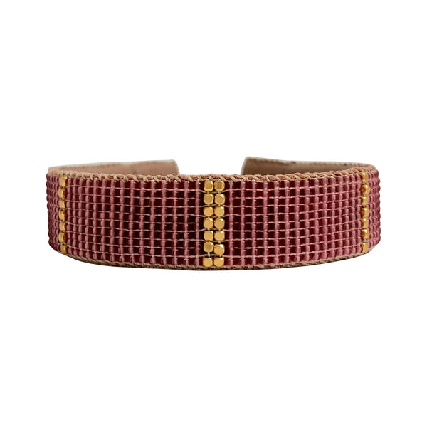 Empire armbåndet fra Ibu Jewels er et perlearmbånd med en mørk pink perle og guld perler på langs midt på armbåndet
