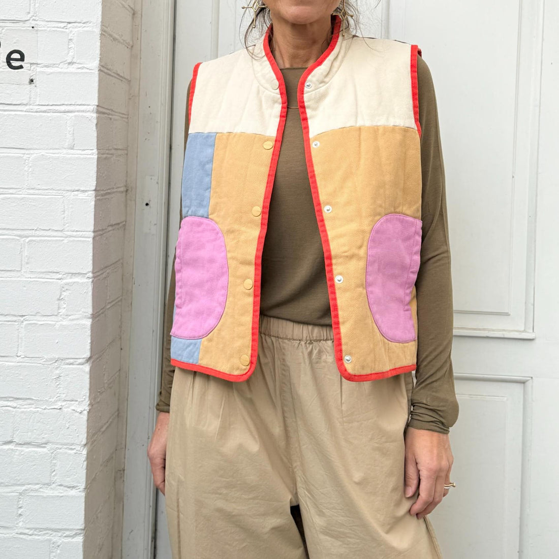 Let quiltet vest i multicolor design med rød kant