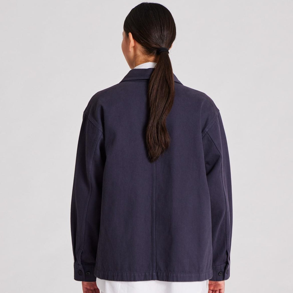 Ellie er en workwear-inspireret jakke, som er lavet af 100% økologisk bomuld. Jakken kan knappes hele vejen ned.  Den er i farven 'After Midnight', som er en mørkeblå jakke