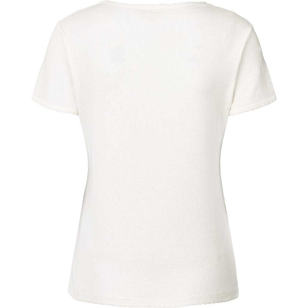 Chrisstine er en kortærmet t-shirt, som er lavet i 100% økologisk bomuld. T-shirten er lavet i et fint pointellemønster med blondekant på halsudskæring, ærmer og nederst. Chrisstine t-shirten har en regulær pasform, og er fin for sig selv eller indenunder skjorter eller striktrøjer. 