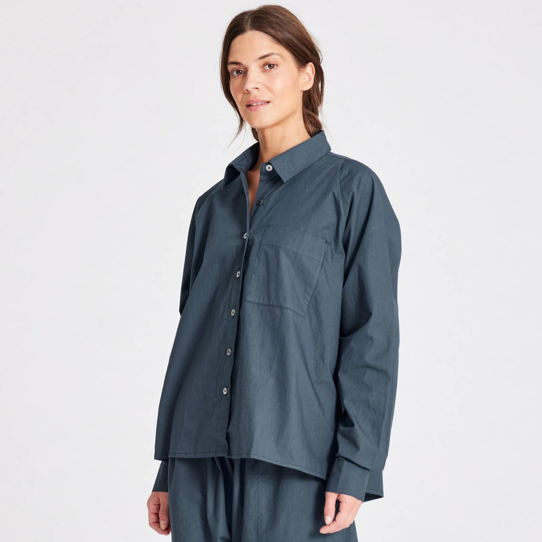 Bella er en klassisk langærmet skjorte fra Gai+Lisva i blå med en lomme på brystet, krave og knappes hele vejen ned.