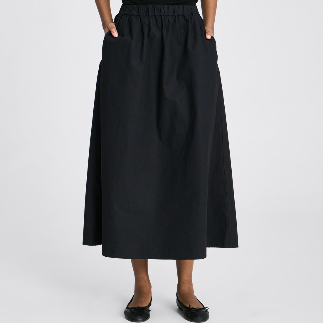 Sort Alice nederdel med let A-form, slidsdetaljer og praktiske stiklommer.