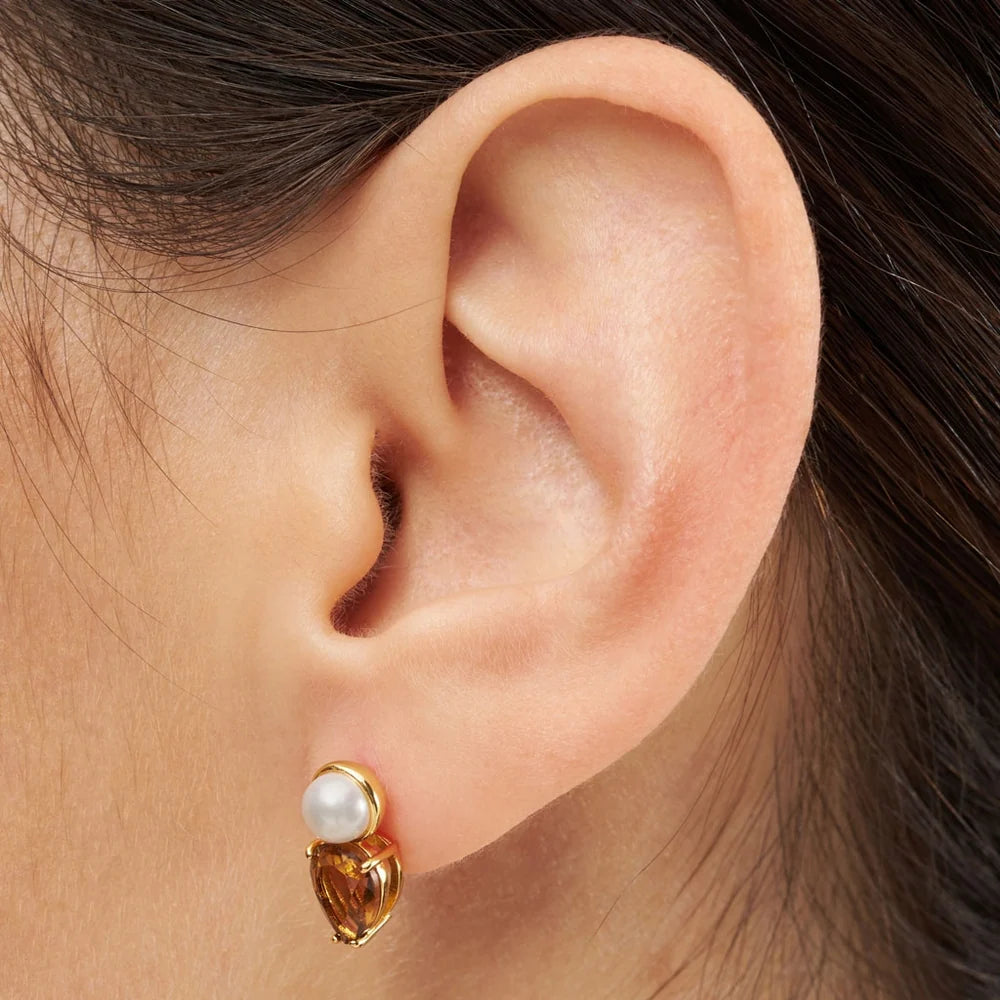 LULU CPH Galla The Drop ørestik i guld med ferskvandsperle og en brun krystal sten som sammen danner et fint smykke