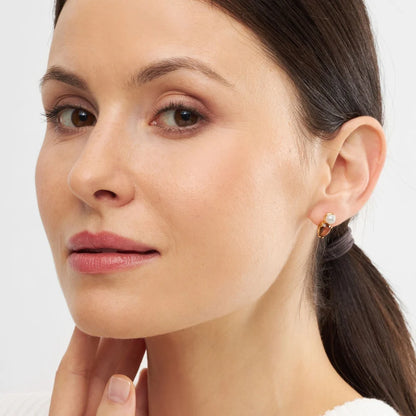 LULU CPH Galla The Drop ørestik i guld med ferskvandsperle og en brun krystal sten som sammen danner et fint smykke