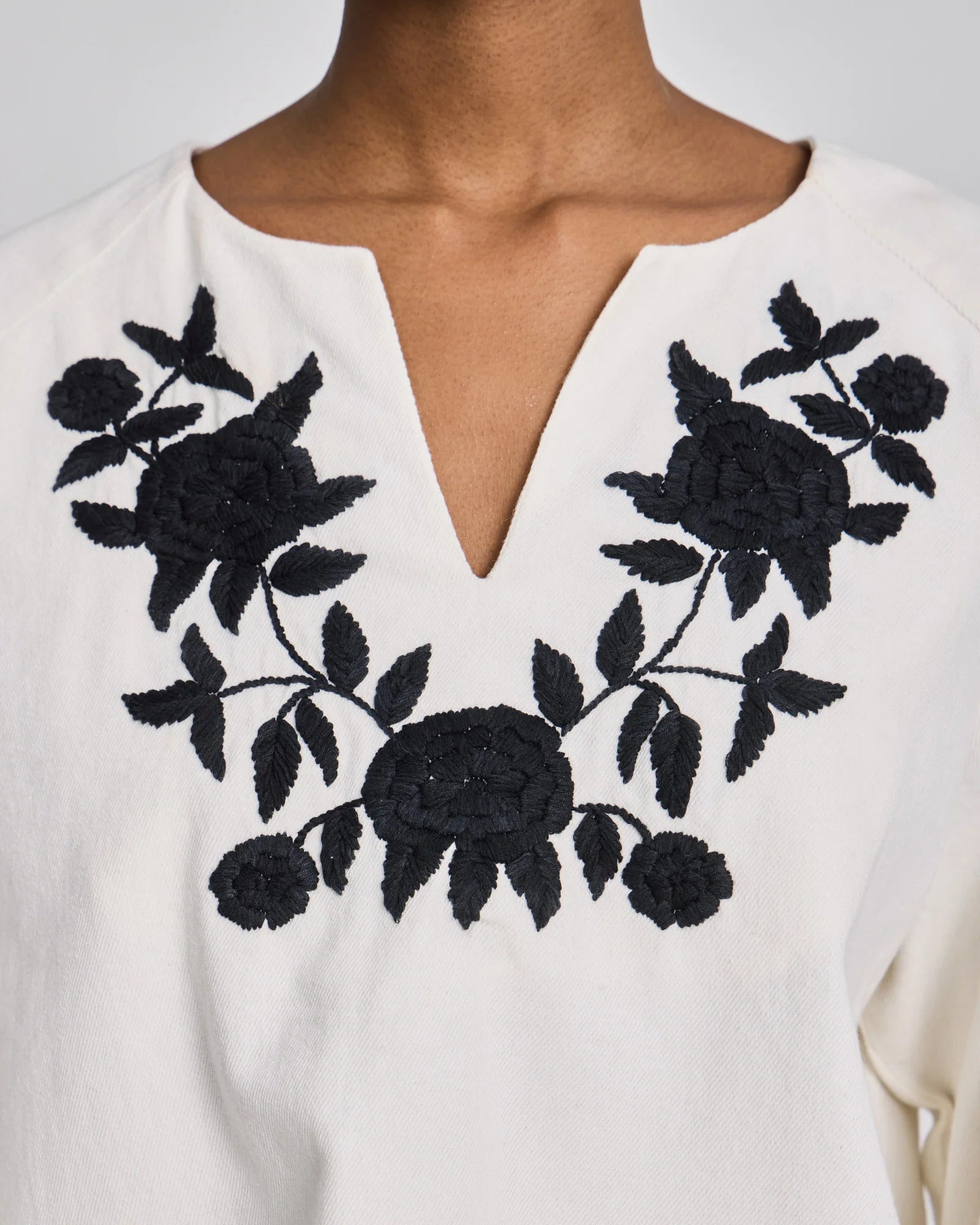 Detaljebillede af Inga blusens broderi på ærmet i 100% økologisk bomuld med fine manchetknapper.