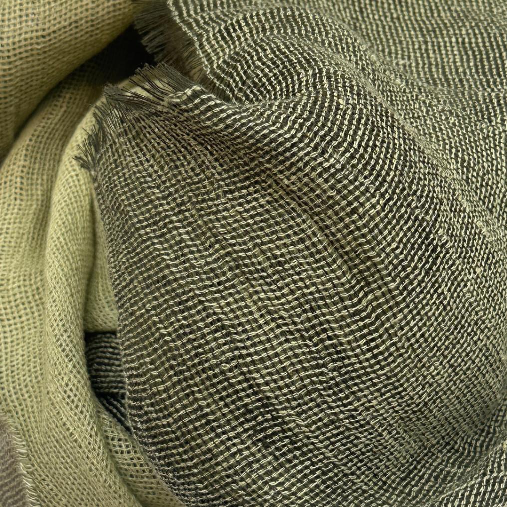 Et grønt tørklæde med en sort kant. Tørklædet er lavet i hør