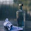mundblæst vandflaske i en svag mørkeblå farve