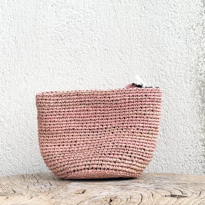 Fin og feminin raffia-pung fra Rabarany i en støvet rosa tone – giver et diskret farvepift til dit outfit.