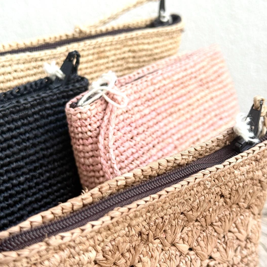 Fin og feminin raffia-pung fra Rabarany i en støvet rosa tone – giver et diskret farvepift til dit outfit.