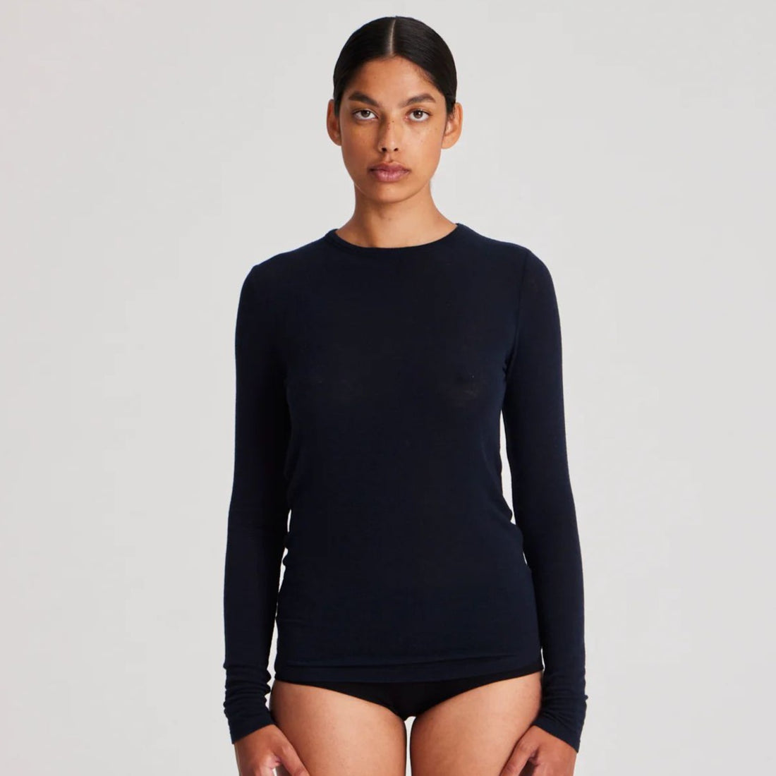 Thyra er en langærmet basisbluse i uld, som holder dig varm. Den er høj i halsen og er mørkeblå