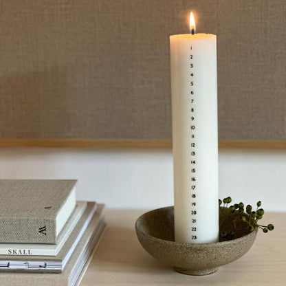 Hvidt og bredt kalenderlys fra Åbenlys i soja og stearin med sorte tal fra 